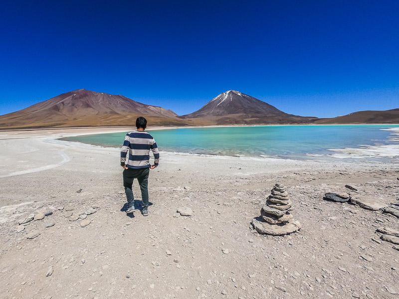 A turquoise green lake with volcano Licancabur in the background